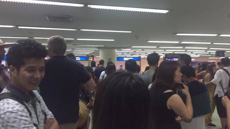 the crowded, hot and very slow moving immigration hall at the old airport in bangkok, avoid it